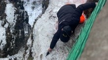 峨眉山工作人员脚踩冰雪沿着悬崖帮游客捡手机 景区回应